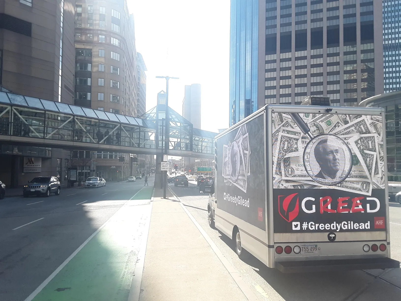 Rear screen of a billboard truck displaying Greedy Gilead advocacy creative on a city street
