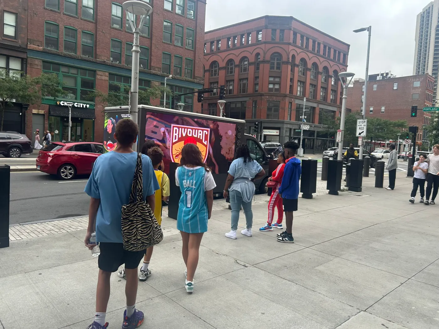 Pedestrians in Boston stopping to look at the BIG3 LED billboard truck at a downtown intersection