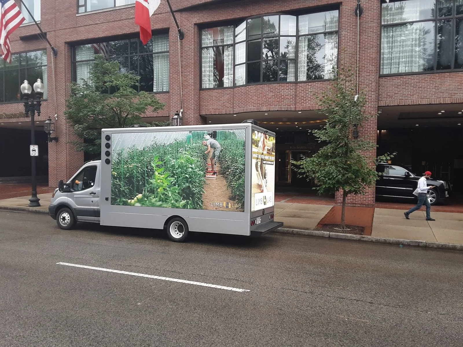 LED billboard truck displaying vibrant advertising graphics driving through a bustling city.