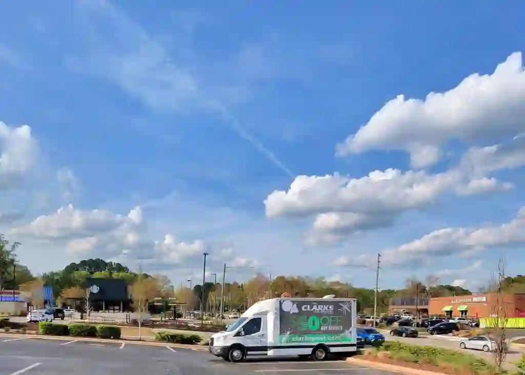 Clark's Pest Control digital billboard truck displaying $50 off offer in a Raleigh shopping center parking lot