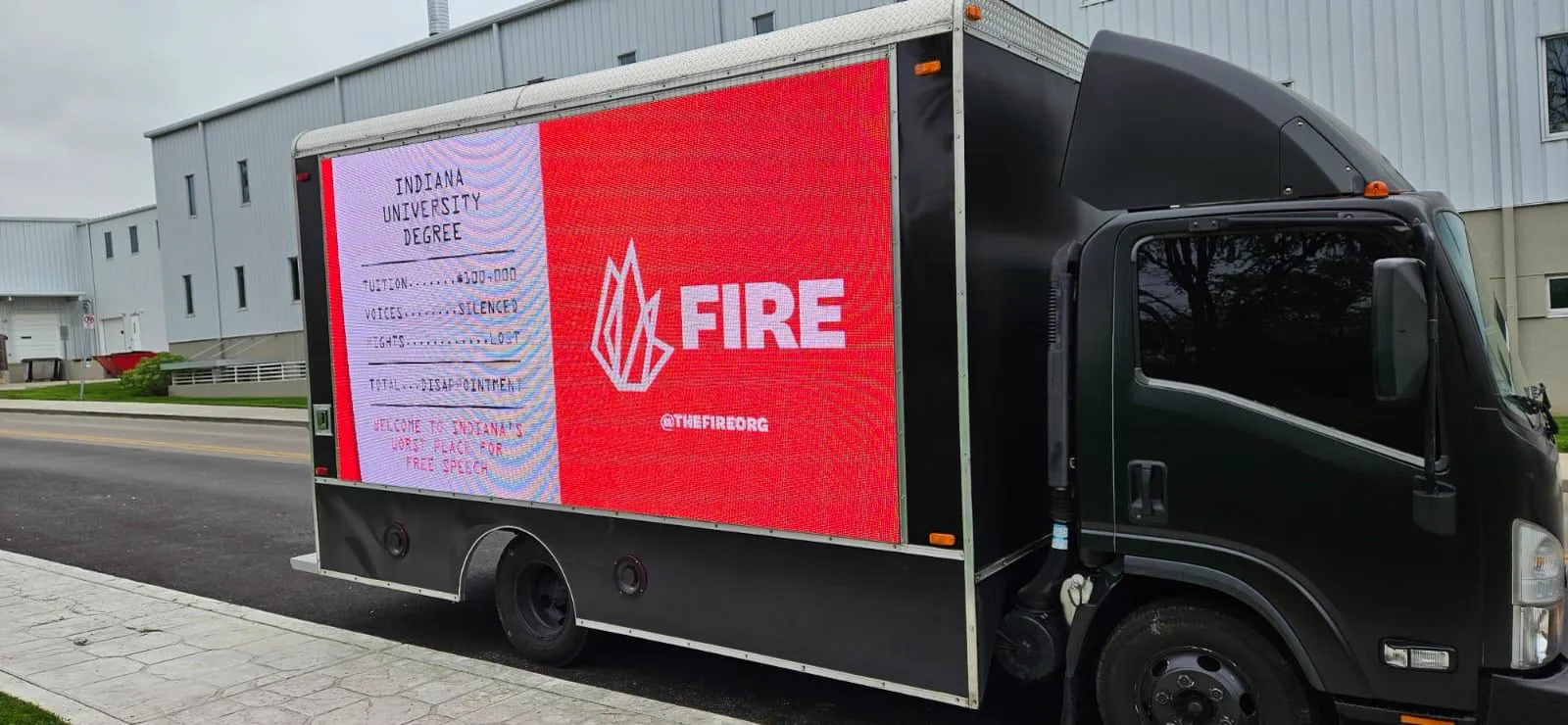 FIRE campus advertising LED billboard truck on a public street in Bloomington, Indiana