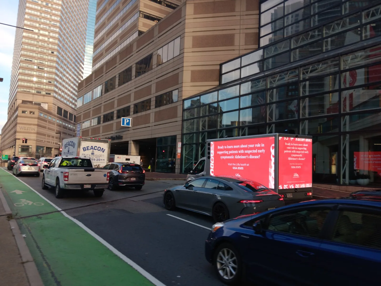 GSA 2025 pharmaceutical LED truck advertising in downtown Boston traffic near the convention district