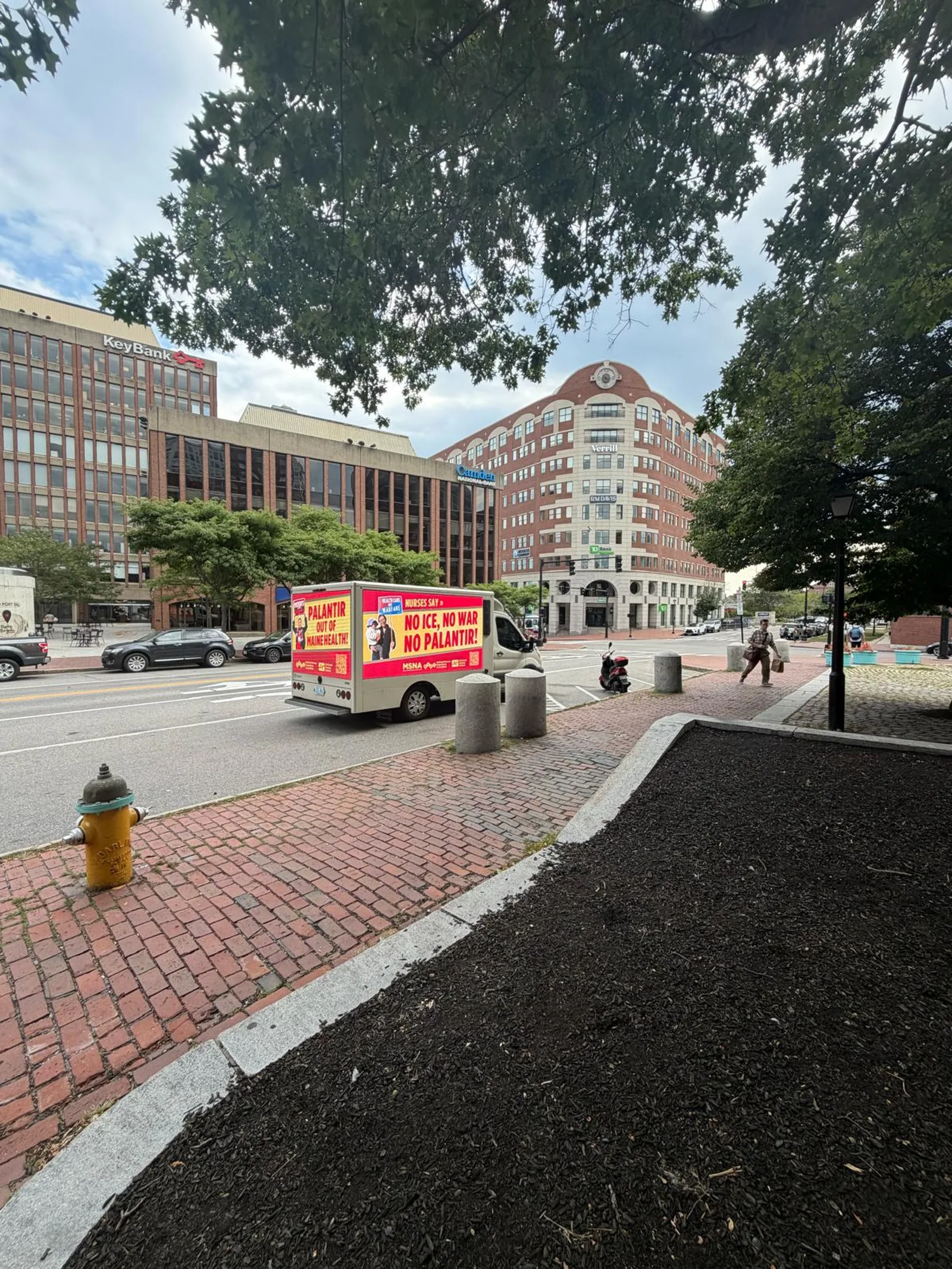 LED billboard truck advertising in Monument Square Portland Maine with KeyBank and Camden National buildings in the background