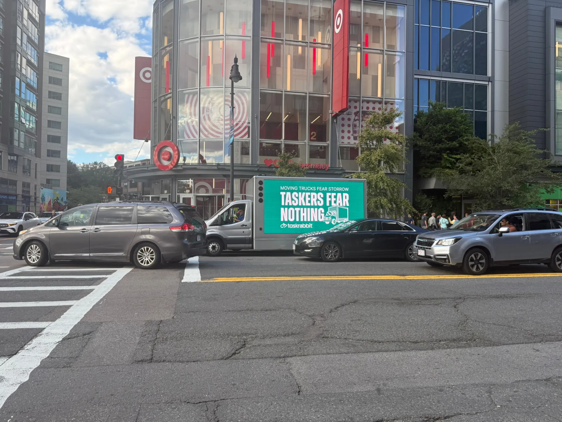 Mobile LED billboard truck displaying TaskRabbit back-to-school ad in traffic outside the Fenway Target in Boston