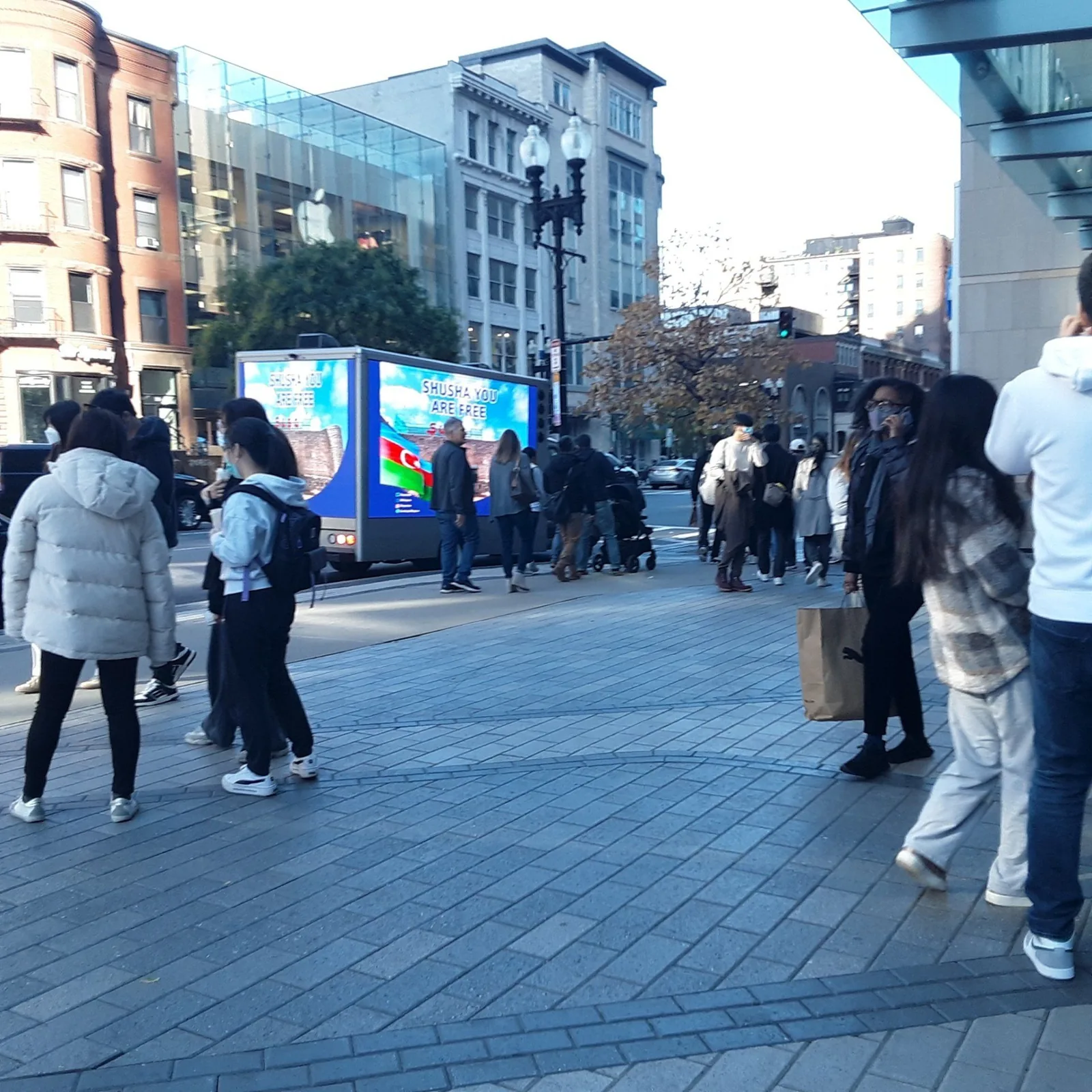 LED billboard truck drawing a crowd of shoppers on a busy city street — the same game-day and retail crowds found around Wrigleyville and the Magnificent Mile in Chicago