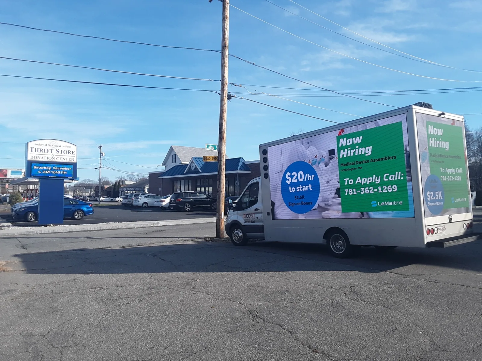 Mobile LED billboard truck running a Now Hiring recruitment ad for medical device assemblers with $20/hr pay and a $2,500 sign-on bonus