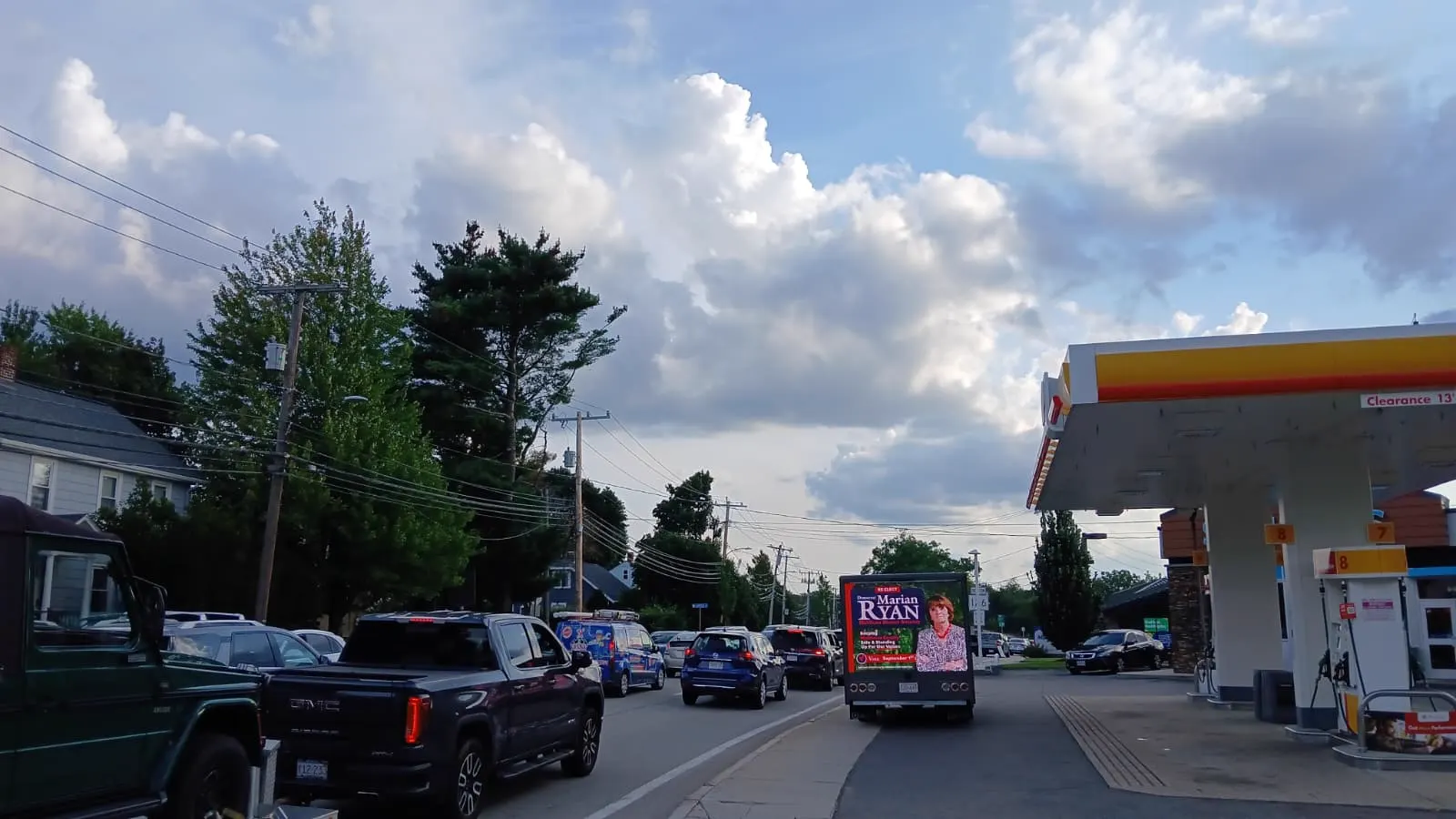 Mobile LED billboard truck for the Marian Ryan campaign in evening commuter traffic beside a Shell gas station on a Middlesex County corridor