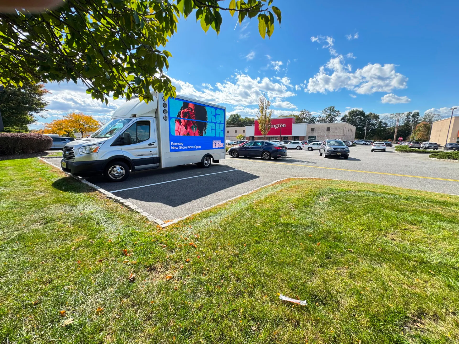 Side view of Boost Outdoor Media’s LED billboard truck displaying Nordstrom Rack creative beside a shopping center during the Ramsey campaign