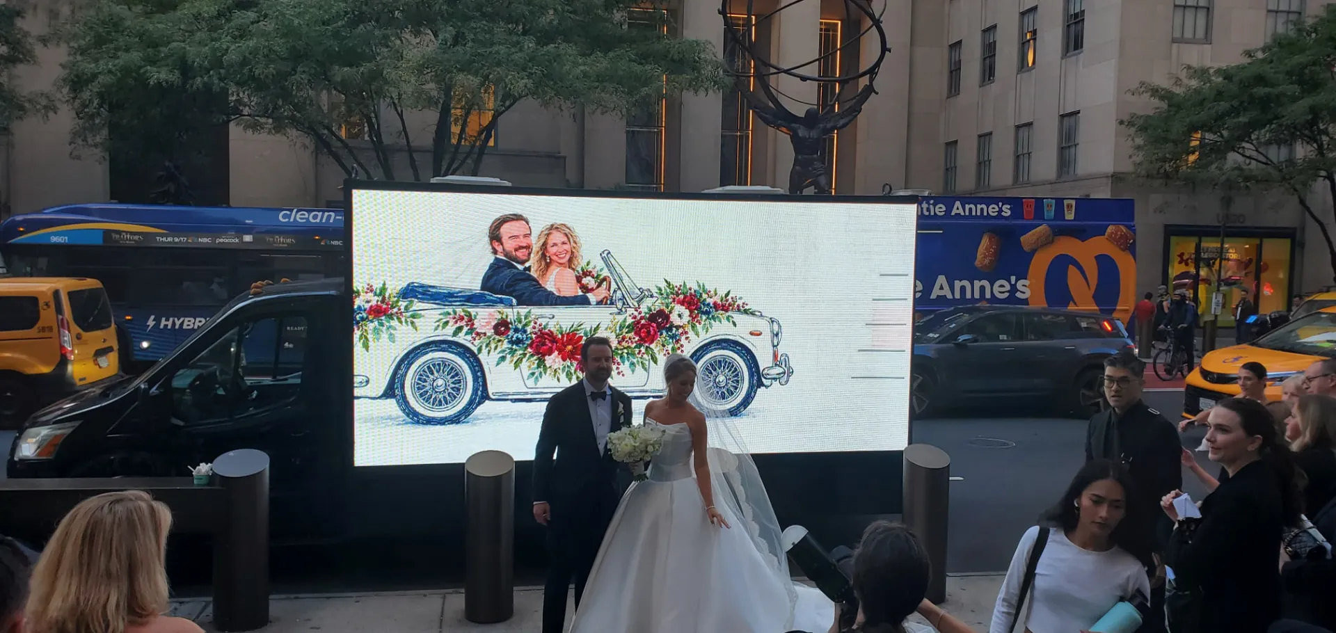 Bride and groom beside a custom wedding LED billboard truck near Rockefeller Center in New York City