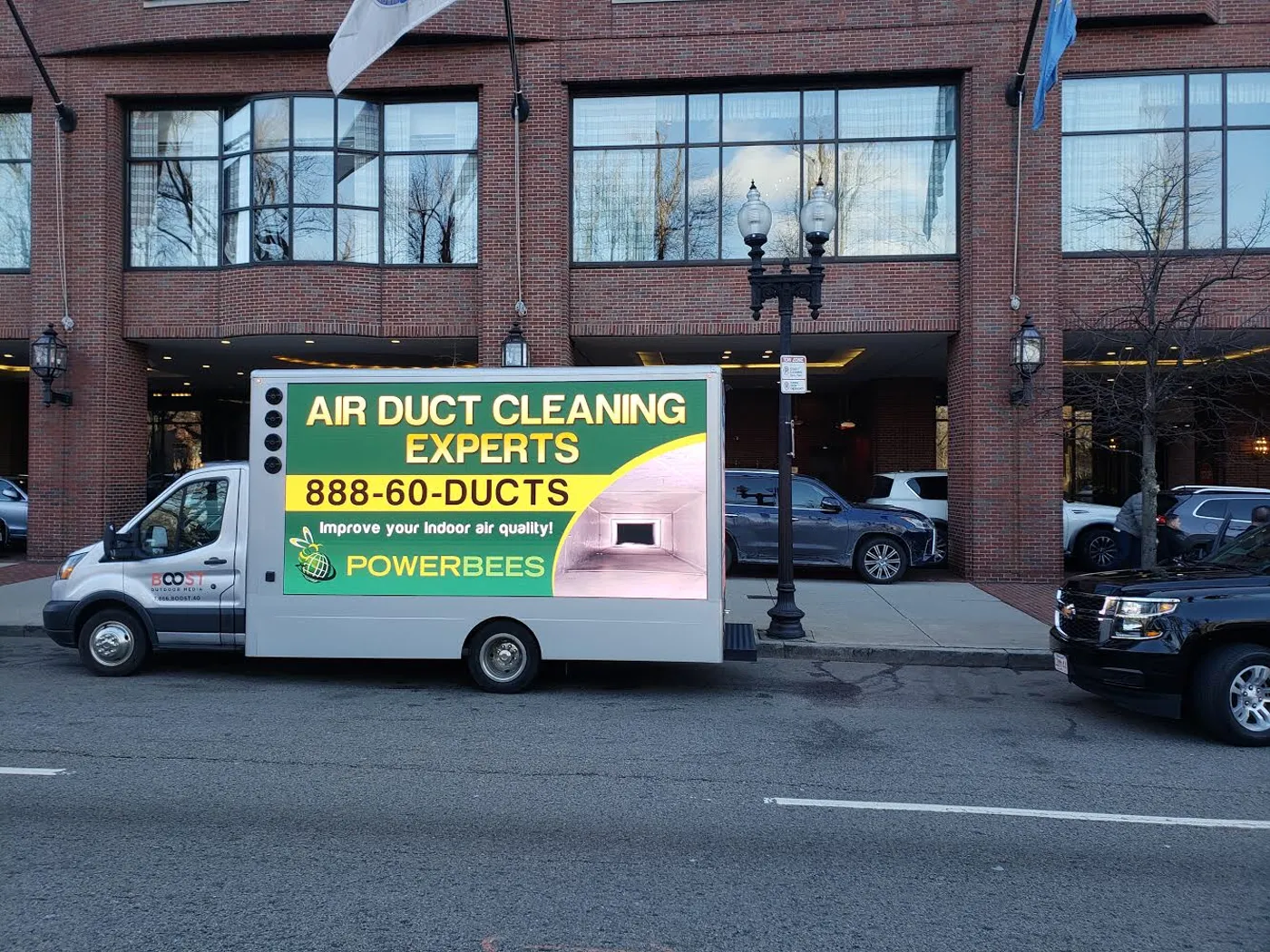 PowerBees air duct cleaning experts LED billboard truck parked in front of a brick hotel in Boston