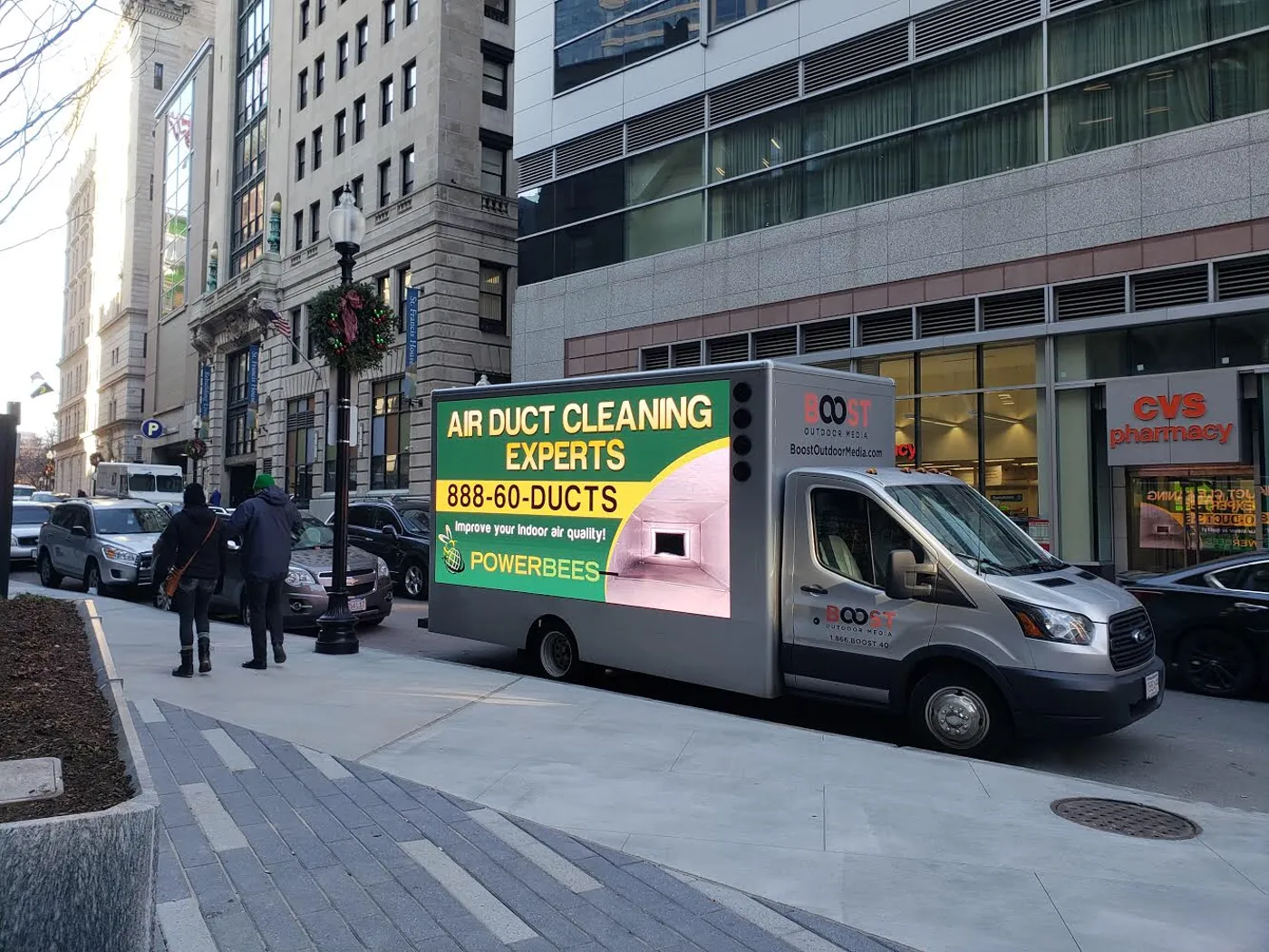 PowerBees LED billboard truck driving past a CVS in downtown Boston