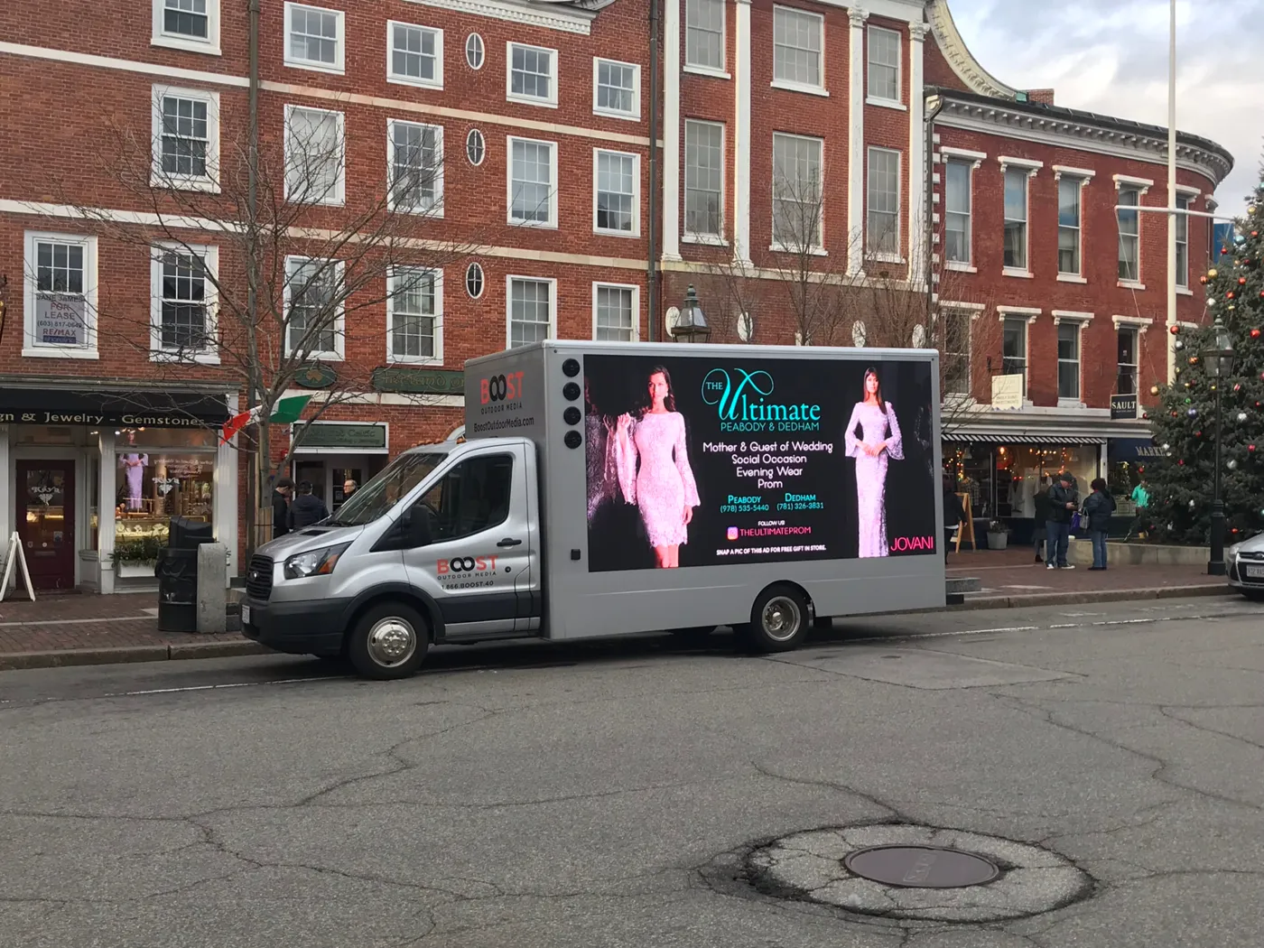 The Ultimate prom and evening wear LED billboard truck with pink Jovani gown creative on a downtown Massachusetts shopping street