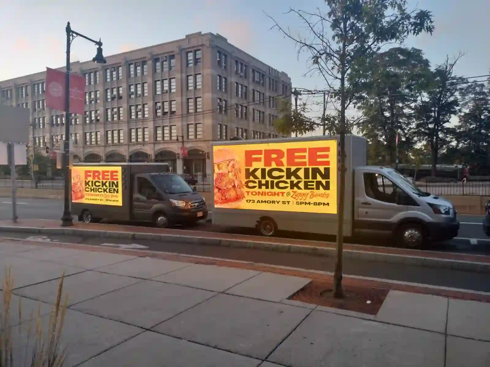 Two LED billboard trucks advertising Ziggy Bombs Free Kickin Chicken night at 173 Amory Street Boston